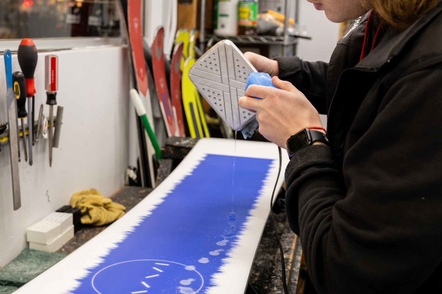 Snowboard being waxed 